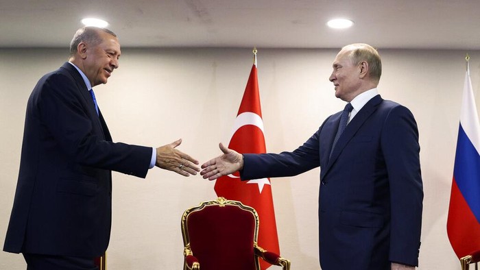 In this handout photo provided by the Turkish Presidency, Turkish President Recep Tayyip Erdogan, left, shakes hands with Russian President Vladimir Putin during their meeting, in Tehran, Iran, Tuesday, July 19, 2022. (Turkish Presidency via AP)