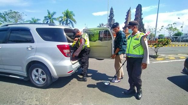Petugas kepolisian melaksanakan pemeriksaan di pintu masuk Bali di Pelabuhan Gilimanuk, Kecamatan Melaya, Kabupaten Jembrana Bali, Senin (18/7/2022)