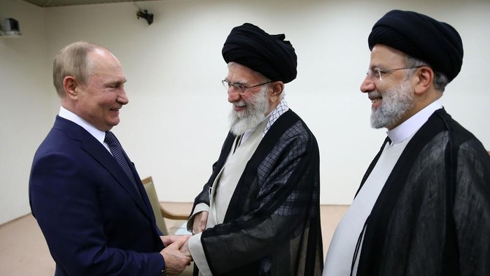 In this picture released by the official website of the office of the Iranian supreme leader, Supreme Leader Ayatollah Ali Khamenei, center, and Russian President Vladimir Putin, left, greet each other as Iranian President Ebrahim Raisi stands at right, during their meeting in Tehran, Iran, Tuesday, July 19, 2022. (Office of the Iranian Supreme Leader via AP)