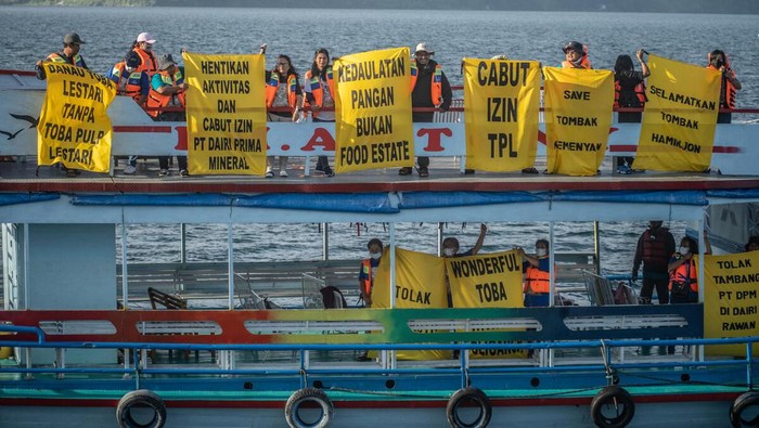 Sebuah spanduk raksasa bertuliskan 'Perempuan Sumatera Utara Menolak Deforestasi' mengapung di kawasan Danau Toba.