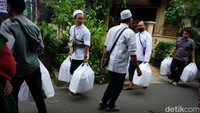 Beberapa orang tampak membawa bungkusan berisi makanan ke dalam gang kediaman Habib Rizieq.
