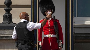 Penjaga istana kerajaan Inggris diberi air minum agar tidak kolaps. Foto: Associated Press