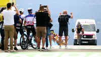 Pebalap satu tim, manajer. pelatih dan penonton memberi semangat kepada Fabio Jakobsen yang nyaris gagal finish pada etape 17 TDF 2022, Rabu, (20/7/2022). Bagi sprinter seperti Jakobsen yang merajai rute datar, melewati rute mendaki parah seperti etape 17 adalah siksaan perih. Sebagai catatan, etape ini cukup pendek hanya 130 km namun di beberapa segmen sampai gradien 17 hingga 20 persen. (Michael Steele/Getty Images)