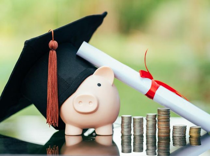 piggy bank With Graduation Cap on black glass floor,Money saving concept.