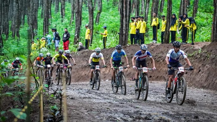 Pebalap sepeda gunung (MTB) beradu cepat pada Kejuaraan Nasional (Kejurnas) Indonesian National Championship (INC) 2022 di sirkuit Agathis Forest Track, Banyuwangi, Jawa Timur, Kamis (21/7/2022). Balap sepeda MTB Cross Country Olimpic (XCO) yang melombakan kategori usia youth, junior, U-23 serta elite putra dan putri itu mengelilingi sirkuit 3,1 kilometer yang berada di lereng Gunung Ijen. ANTARA FOTO/Budi Candra Setya/tom.