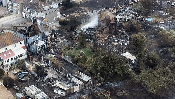 WENNINGTON, GREATER LONDON - JULY 20: An aerial view shows a Union Flag flying among the the rubble and destruction in a residential area, following a large blaze the previous day, on July 20, 2022 in Wennington, Greater London. A series of fires broke out across England yesterday as the UK experienced a record-breaking heatwave. Temperatures in many places reached 40c and over. (Photo by Leon Neal/Getty Images)
