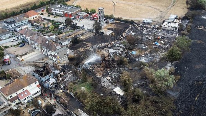 WENNINGTON, GREATER LONDON - JULY 20: An aerial view shows a Union Flag flying among the the rubble and destruction in a residential area, following a large blaze the previous day, on July 20, 2022 in Wennington, Greater London. A series of fires broke out across England yesterday as the UK experienced a record-breaking heatwave. Temperatures in many places reached 40c and over. (Photo by Leon Neal/Getty Images)