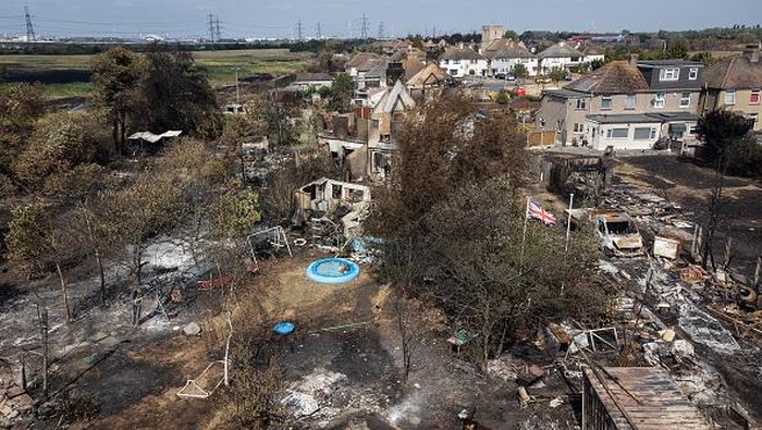 WENNINGTON, GREATER LONDON - JULY 20: An aerial view shows a Union Flag flying among the the rubble and destruction in a residential area, following a large blaze the previous day, on July 20, 2022 in Wennington, Greater London. A series of fires broke out across England yesterday as the UK experienced a record-breaking heatwave. Temperatures in many places reached 40c and over. (Photo by Leon Neal/Getty Images)