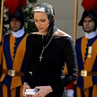 Sebuah gaun hitam dengan garis leher bergaya bateau-neck yang mengekspos bahu menjadi pilihan wanita 44 tahun itu. Di jajaran aksesori, terdapat pula rosario dengan salib yang besar. Sepasang heels berwarna nude turut melengkapi gayanya. (Foto: AFP via Getty Images/TIZIANA FABI)