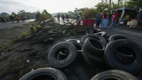 Ban yang menghalangi jalan memaksa para pekerja maupun warga berjalan kaki di Pacora, Panama, Rabu (20/7/2022). Unjukrasa memprotes inflasi khususnya kenaikan harga bahan bakar minyak. 
