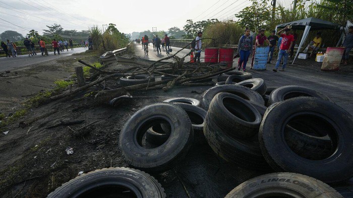 Commuters walk along the Pan American Highway due to roadblocks set up by protesters demonstrating against inflation, especially surging fuel prices, in Pacora, Panama, early Wednesday, July 20, 2022. (AP Photo/Arnulfo Franco)