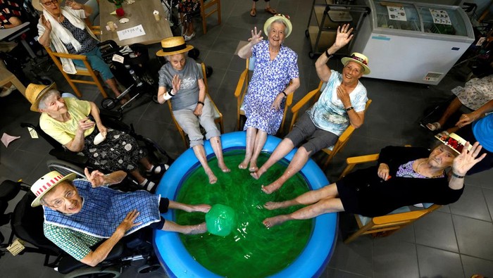 Begini Cara Para Lansia di Belgia Hadapi Gelombang Panas Residents at the Ter Biest house for elderly persons Rachel De Smedt, 89, Marie-Louise Buggenhout, 90, Mariette Van Dam, 90, Lisette Donies, 88 and Irma Van Buggenhout, 93, dip their feet in a pool as a heat wave hits Europe, in Grimbergen, Belgium July 19, 2022. REUTERS/Yves Herman