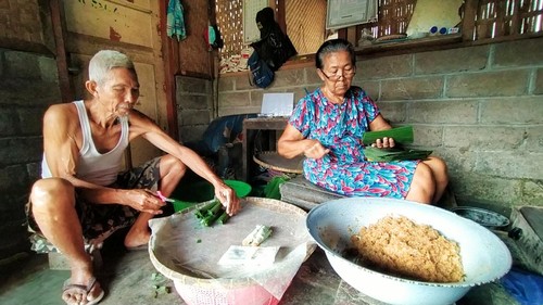 Dayu Ketut Notri, warga Banjar Petanahan, Desa Batu Agung, Kecamatan/Kabupaten Jembrana Bali, ditemani suami saat membuat kue bendu jajanan khas Jembarana, Jumat (22/7/2022).