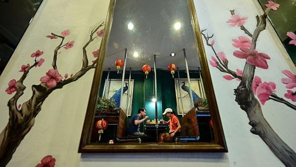 Orang-orang duduk saat makan siang di kafe Lhong Tou di kawasan Chinatown, Bangkok, Thailand, Jumat (22/7/2022) waktu setempat.