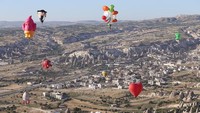 Balon udara panas yang menampilkan berbagai bentuk meluncur di atas langit di Cappadocia, Turki, Jumat (22/7/2022) waktu setempat.  