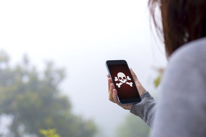 Young woman holding hacked smartphone.