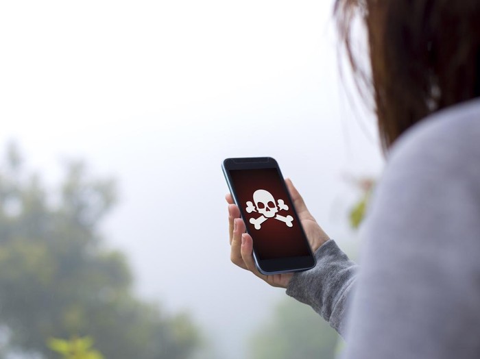 Young woman holding hacked smartphone.