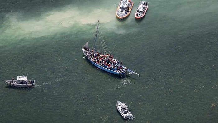 ISLANDIA, FLORIDA - JULY 21: Law enforcement officials along with U.S. Coast Guard sail near a sailboat containing approximately 150 migrants on July 21, 2022 in Islandia, Florida. U.S. Coast Guard, Miami-Dade police and other law enforcement agencies are processing the migrants after they were intercepted near Boca Chita Key Thursday morning. (Photo by Joe Raedle/Getty Images)