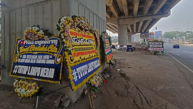 Karangan bunga 'tutup lampu merah' di pertigaan CBD, Cibubur, Bekasi, Jumat (22/7/2022)