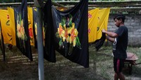 Perajin mengeringkan kain pantai setelah diwarnai. Kain pantai tersebut dijual dengan harga Rp 80.000 per buah.