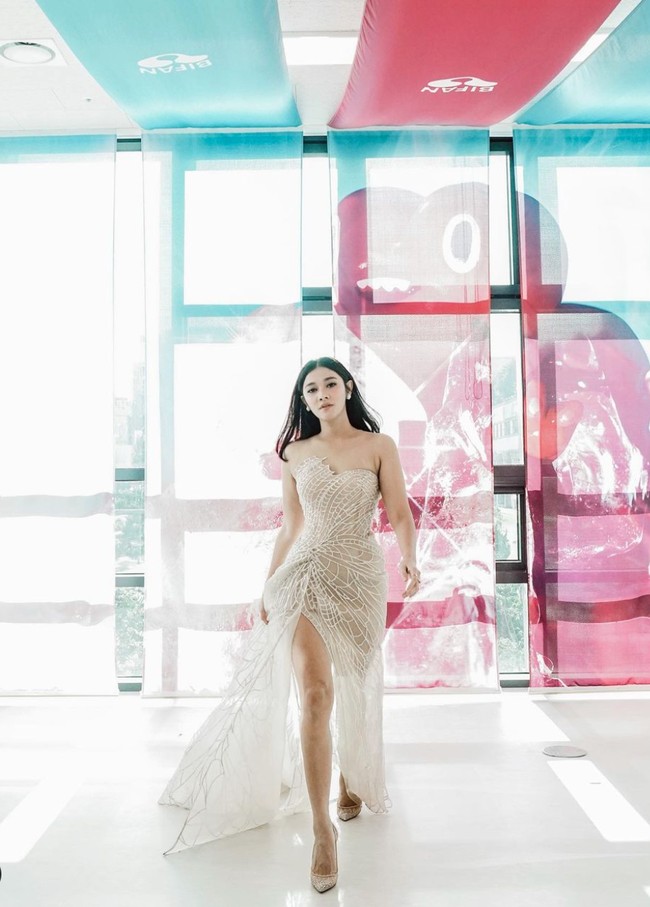 Untuk menghadiri awarding night film INANG di BIFAN, Naysilla memilih dress strapless bernuansa nude yang memiliki belahan cukup tinggi sampai ke paha. Penampilannya kian menawan dengan heels berwarna senada. Foto: Instagram/@naymirdad
