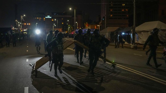 Army soldiers remove tents from the site of a protest camp outside the Presidential Secretariat in Colombo, Sri Lanka, Friday, July 22, 2022. (AP Photo/Rafiq Maqbool)
