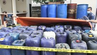 Sejumlah petugas Kepolisian mempersiapkan barang bukti sebelum rilis kasus penyalahgunaan BBM (Bahan Bakar Minyak) subsidi jenis solar di Kabupaten Bekasi, Jawa Barat, Jumat (22/7/2022).