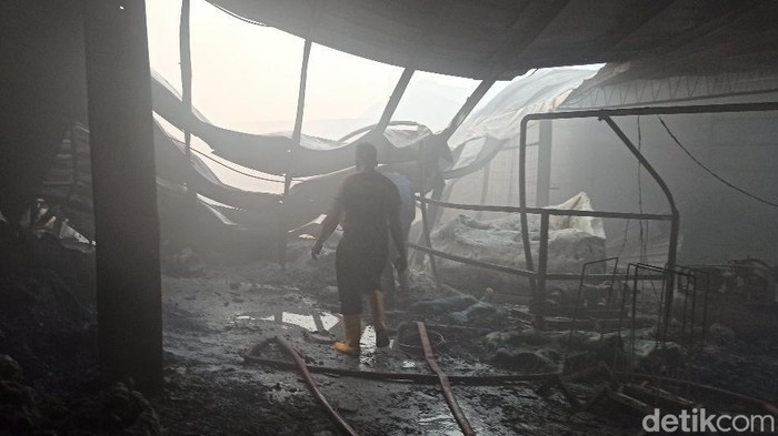 Petugas melakukan pendinginan pabrik pupuk di Mranggen yang terbakar, Jumat (22/7/2022).
