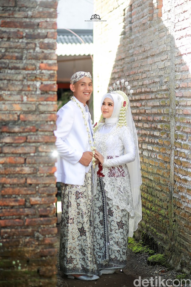 Kedua pengantin kompak memakai busana serba putih dengan bawahan kain batik. Fotografer juga membagikan hasil sesi foto dan sukses membuat warganet kagum.  Foto: Dok. pribadi @pcp_studio.