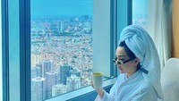 Saat pagi hari, Cupi Cupita paling senang menikmati segelas minuman hangat. Sambil memandangi kota ia menikmati pagi masih dengan handuk di kepalanya. Foto: Instagram/cupitagobas19