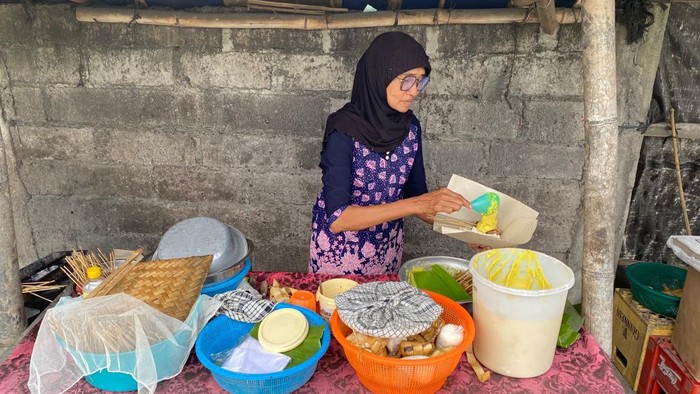 Rumeneh saat menyajikan satu porsi sate serapah khas Karangasem