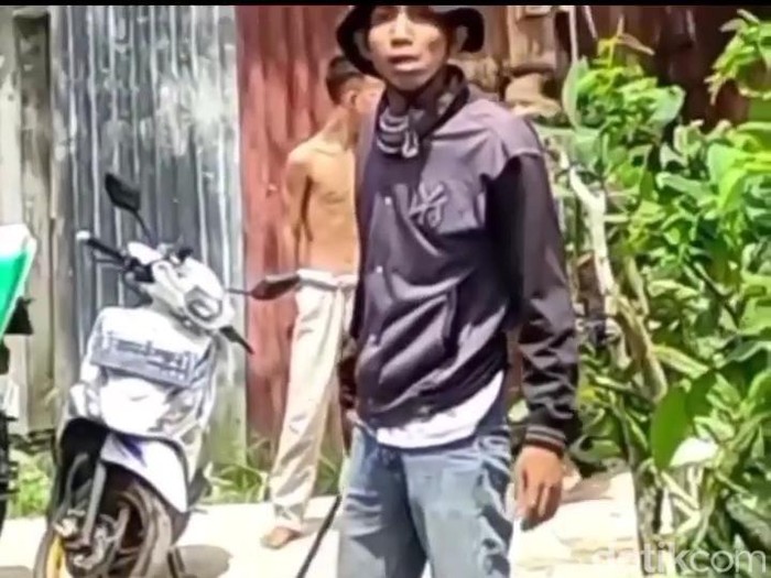 Seorang pria mengancam perempuan dengan parang.