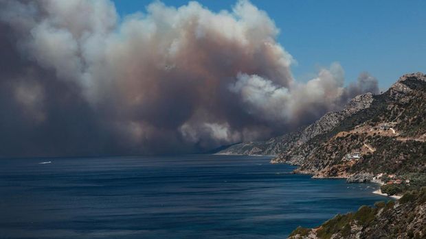 TOPSHOT - The smoke of a wildfire billows as it approaches Vatera coastal resort on the eastern island of Lesbos on July 23, 2022. - Residents were evacuated as the wilfire threatened properties. (Photo by Manolis LAGOUTARIS / AFP) (Photo by MANOLIS LAGOUTARIS/AFP via Getty Images)