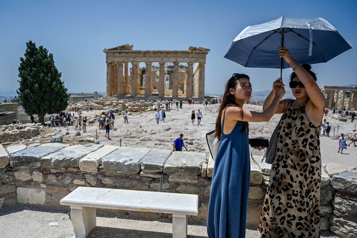 Turis di Acropolis, Athena kepanasan saat suhu udara mencapai 42 derajat celsius pada 24 Juli 2022. (Louisa Goulimaki/AFP via Getty Images)