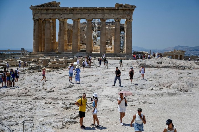 Turis di Acropolis, Athena kepanasan saat suhu udara mencapai 42 derajat celsius pada 24 Juli 2022. (Louisa Goulimaki/AFP via Getty Images)