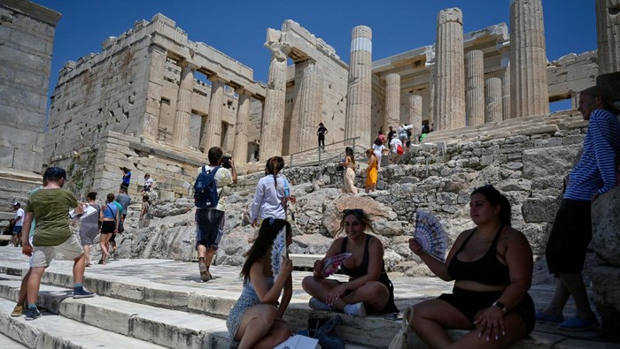 Turis di Acropolis, Athena kepanasan saat suhu udara mencapai 42 derajat celsius pada 24 Juli 2022. (Louisa Goulimaki/AFP via Getty Images)