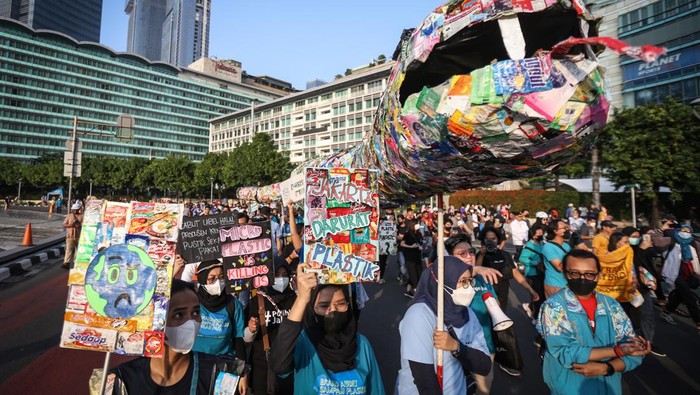 Sejumlah pegiat lingkungan membawa poster dan instalasi ular dari sampah plastik saset saat pawai bebas plastik di Kawasan Sudirman, Jakarta, Minggu (24/7/2022).  Pawai yang diinisiasi sejumlah organisasi lingkungan itu merupakan salah satu bentuk kampanye menyadarkan masyarakat dan produsen kemasan saset agar tidak menggunakan plastik sekali pakai karena sulit diurai. ANTARA FOTO/Asprilla Dwi Adha/foc.