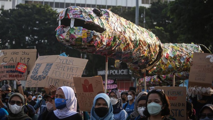 Sejumlah pegiat lingkungan membawa poster dan instalasi ular dari sampah plastik saset saat pawai bebas plastik di Kawasan Sudirman, Jakarta, Minggu (24/7/2022).  Pawai yang diinisiasi sejumlah organisasi lingkungan itu merupakan salah satu bentuk kampanye menyadarkan masyarakat dan produsen kemasan saset agar tidak menggunakan plastik sekali pakai karena sulit diurai. ANTARA FOTO/Asprilla Dwi Adha/foc.