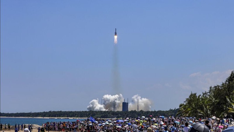 In this photo released by Xinhua News Agency, people gather at the beach side as they watch the Long March 5B Y3 carrier rocket, carrying Wentian lab module, lift off from the Wenchang Space Launch Center in Wenchang in southern China's Hainan Province Sunday, July 24, 2022. On a hot Sunday afternoon, with a large crowd of amateur photographers and space enthusiasts watching, China launched the Wentian lab module from tropical Hainan Island. (Zhang Liyun/Xinhua via AP)