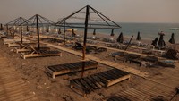 Penampakan bar dan payung pantai yang hangus usai kebakaran. REUTERS/Alexandros Avramidis