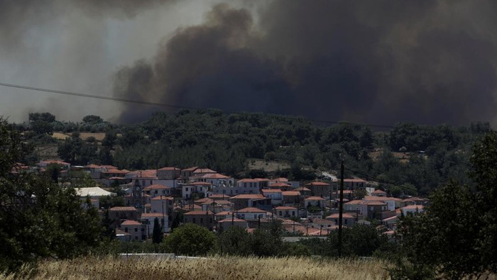 Kebakaran Hutan Hanguskan Sejumlah Rumah di Pulau Lesbos, Yunani Smoke rises as wildfire burns near the village of Vrisa, on the island of Lesbos, Greece July 23, 2022. REUTERS/Elias Marcou
