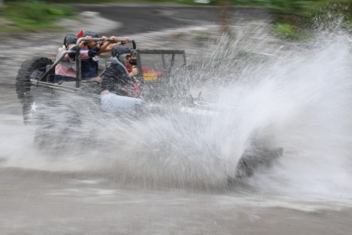 Wisatawan menumpang mobil Jip ketika mengikuti wisata 