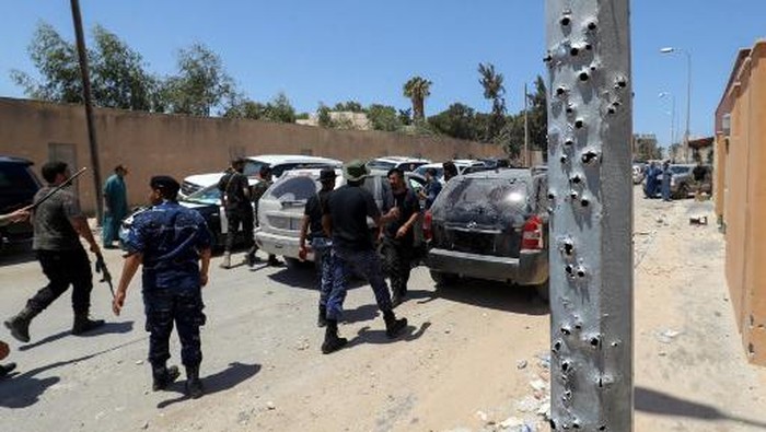 A convoy of cars transporting the Libyan army chief of staff, arrives at a neighbourhood in the capital Tripoli on July 23, 2022, bearing damage caused by recent fighting between armed groups. - At least 16 people were killed and 52 wounded in fighting between armed groups in Tripoli, that started on July 21 and extended into July 22, the health ministry said today. (Photo by Mahmud Turkia / AFP)