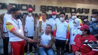 Atlet cabor para atletik National Paralympic Committee (NPC) Indonesia Jaenal Aripin (tengah) membawa api obor disaksikan Menteri Pariwisata dan Ekonomi Kreatif (Menparekraf) Sandiaga Uno (kiri), Wali Kota Solo yang juga Ketua INASPOC 2022 Gibran Rakabuming Raka (ketiga kanan) dan Ketua umum National Paralympic Committee (NPC) Indonesia Senny Marbun (kanan) saat torch relay atau pawai obor ASEAN Para Games 2022 di Stadion Sriwedari, Solo, Jawa Tengah, Minggu (24/7/2022).