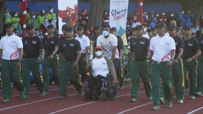 Momen Sandiaga Uno-Gibran Ramaikan Pawai Obor ASEAN Para Games Atlet cabor para atletik National Paralympic Committee (NPC) Indonesia Jaenal Aripin (tengah) membawa api obor disaksikan Menteri Pariwisata dan Ekonomi Kreatif (Menparekraf) Sandiaga Uno (kiri), Wali Kota Solo yang juga Ketua INASPOC 2022 Gibran Rakabuming Raka (ketiga kanan) dan Ketua umum National Paralympic Committee (NPC) Indonesia Senny Marbun (kanan) saat torch relay atau pawai obor ASEAN Para Games 2022 di Stadion Sriwedari, Solo, Jawa Tengah, Minggu (24/7/2022). Indonesia menjadi tuan rumah ajang ASEAN Para Games XI 2022 yang akan mempertandingkan 14 cabang olahraga dan diikuti 11 negara-negara Asia Tenggara pada 30 Juli-6 Agustus 2022 mendatang. ANTARAFOTO/Maulana Surya/foc.