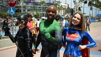 Cosplayer Catwoman, Green Lantern dan Supergirl berpose di luar pusat konvensi selama Comic-Con International 2022, (22/7/2022), di San Diego, California.