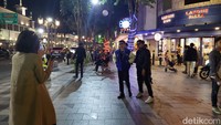 Usai dibubarkan, warga kemudian berpencar. Meski demikian, mereka tetap memeragakan busana dan berfoto di trotoar jalan Tunjungan/Foto: Esti Widiyana