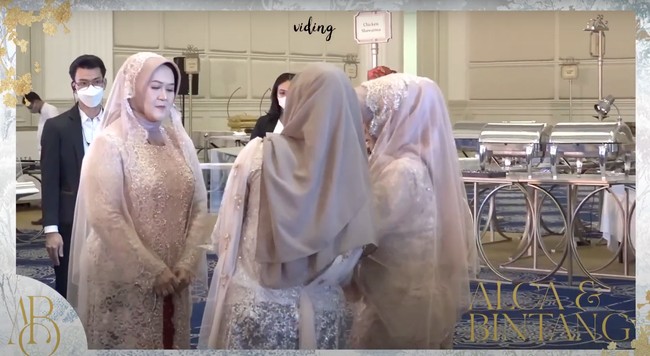 Acara diawali dengan tradisi adat Betawi, di mana kedua keluarga saling berpantun dan melakukan tarian pencak silat. Setelahnya dilanjutkan dengan pemberian seserahan dari keluarga Bintang Emon untuk Alca yang diwakili oleh kedua ibu mempelai. Foto: YouTube/Bintang Emon