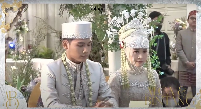 Setelah ijab kabul selesai diucapkan barulah Bintang Emon menjemput Alca untuk sama-sama menandatangani berkas-berkas pernikahan. Terlihat keduanya kompak mengenakan busana pengantin berwarna abu-abu. Foto: YouTube/Bintang Emon