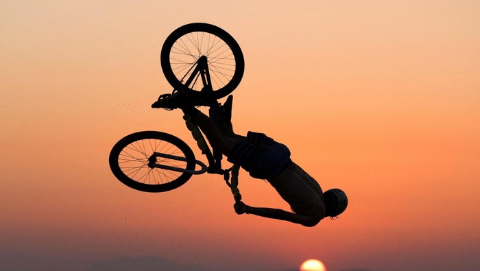 A biker performs tricks at Kavouri beach during a heatwave near Athens, Greece July 24, 2022. REUTERS/Stelios Misinas